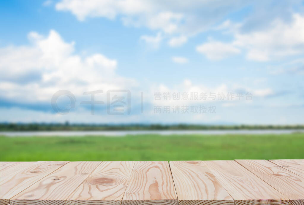 Empty wooden board table top on of blurred blue sky and river b