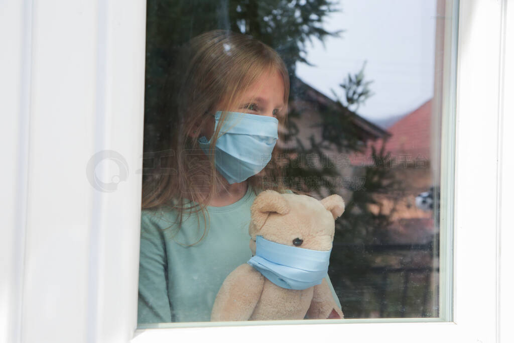 Stay at home.Sad girl wearing protection mask with toy bear look