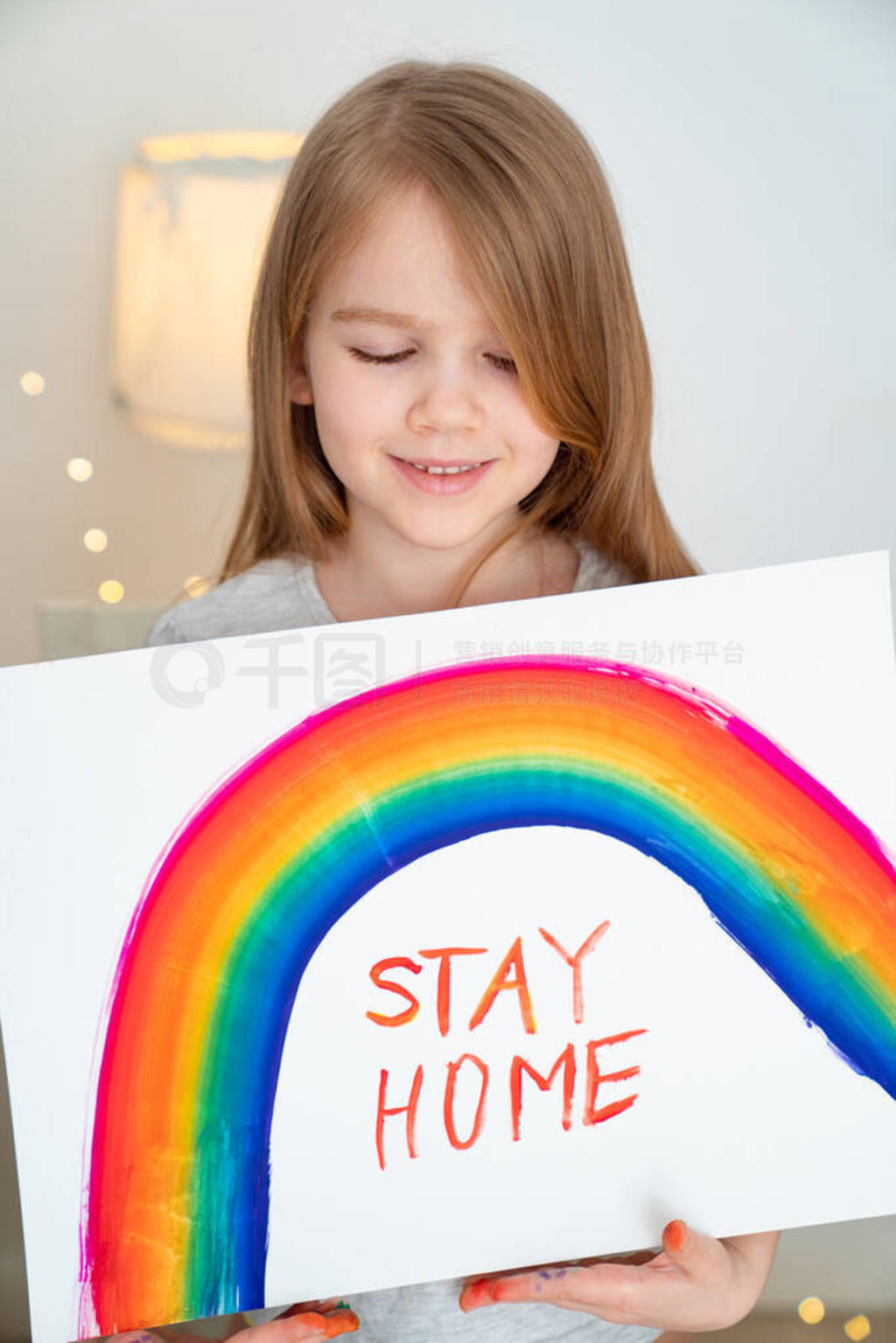 small girl drew rainbow and poster stay home.