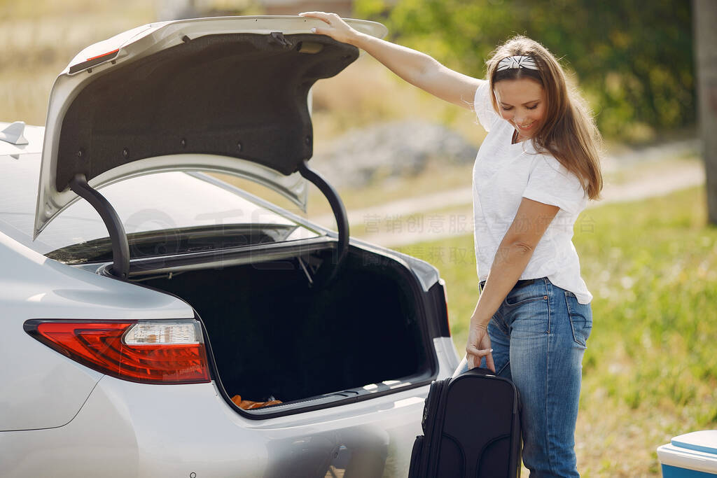 Elegant woman removes the suitcase from the trunk