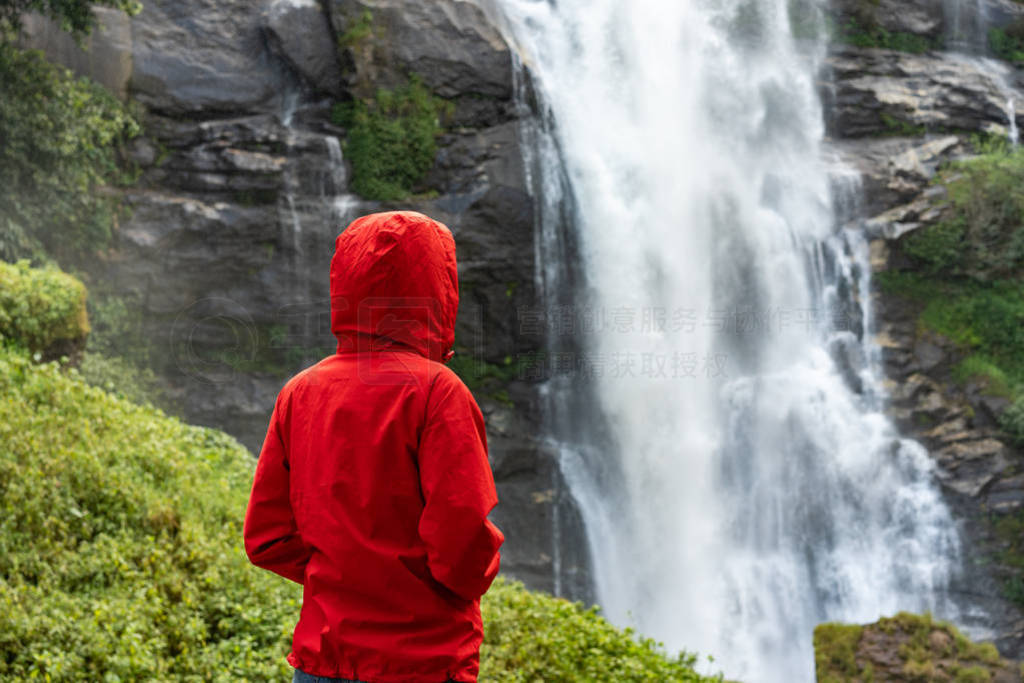 Woman hiker looking on waterfall outdoor. Tourism concept