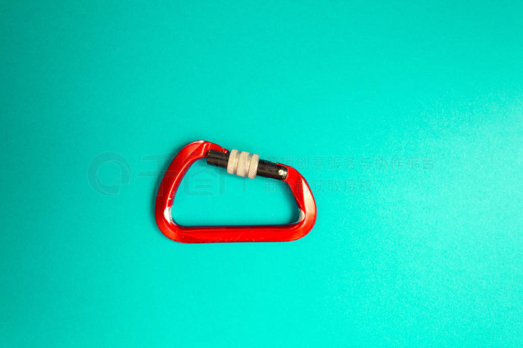 Red carabiner with clutch on a blue background.