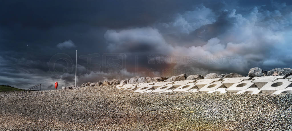 Stones and concrete blocks in Garretstown beach shore on cloudy
