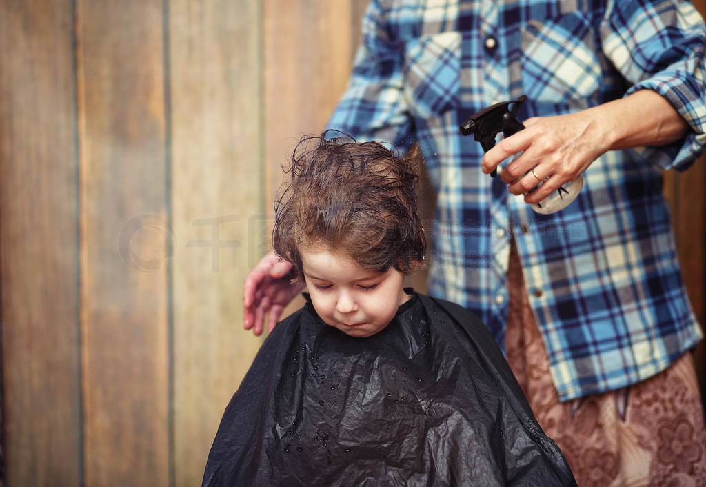 A little boy is trimmed in the hairdresser's