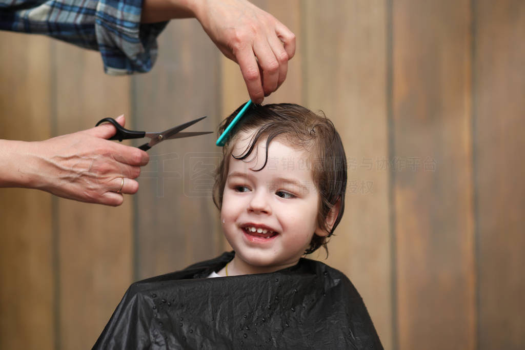 A little boy is trimmed in the hairdresser's bright emotions on