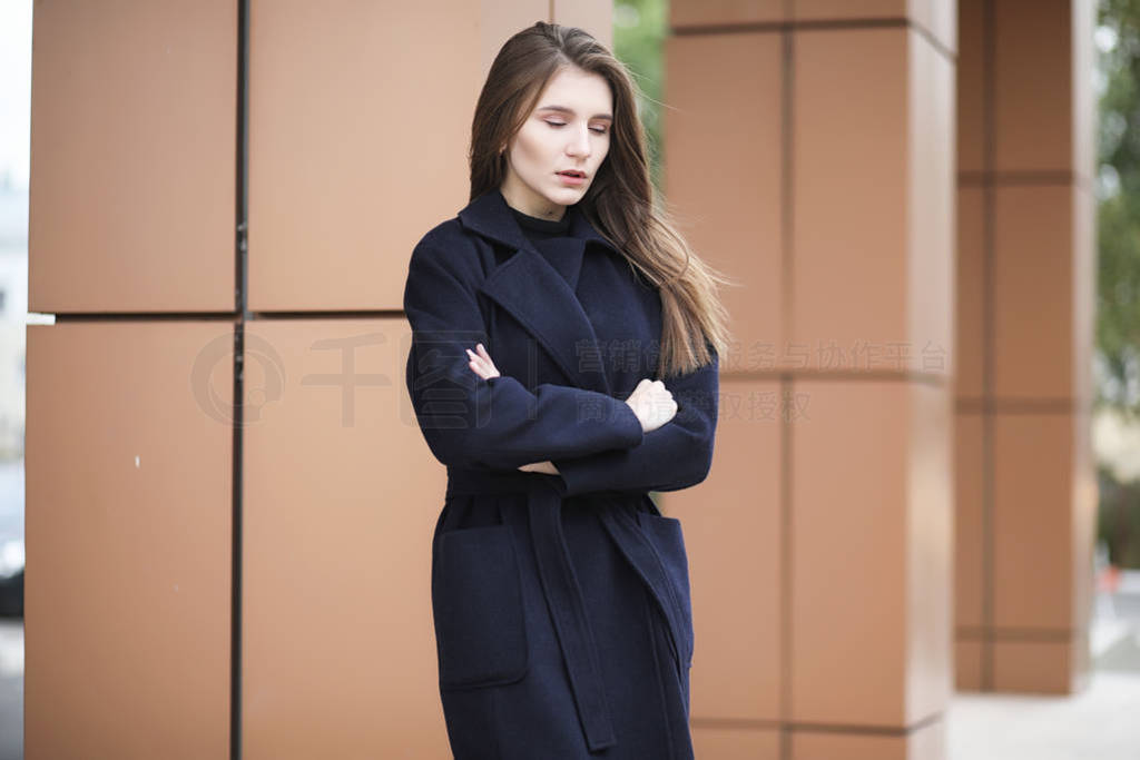 Beautiful girl in a coat in business downtown