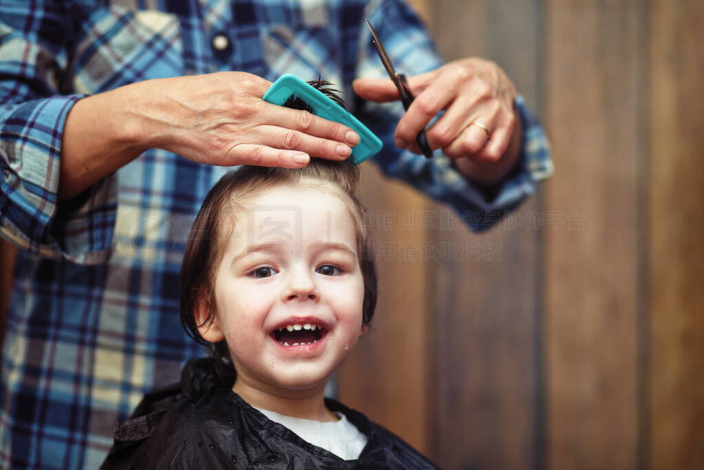 A little boy is trimmed in the hairdresser's