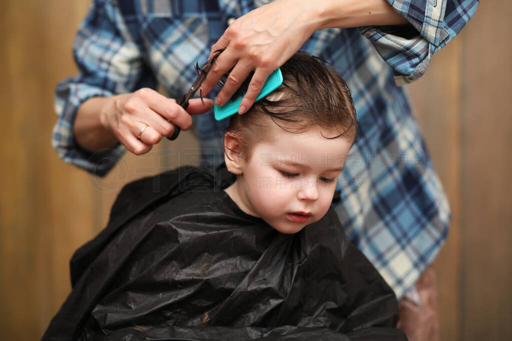 A little boy is trimmed in the hairdresser's bright emotions on