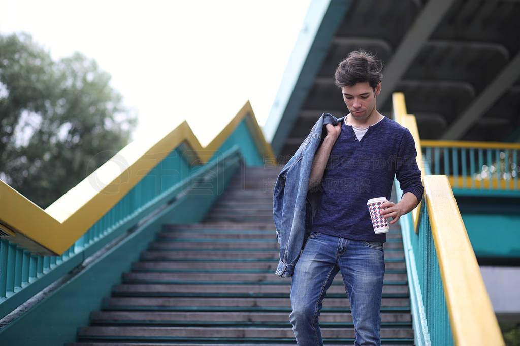 A young man walks in the park at lunch time. A man is on a walk