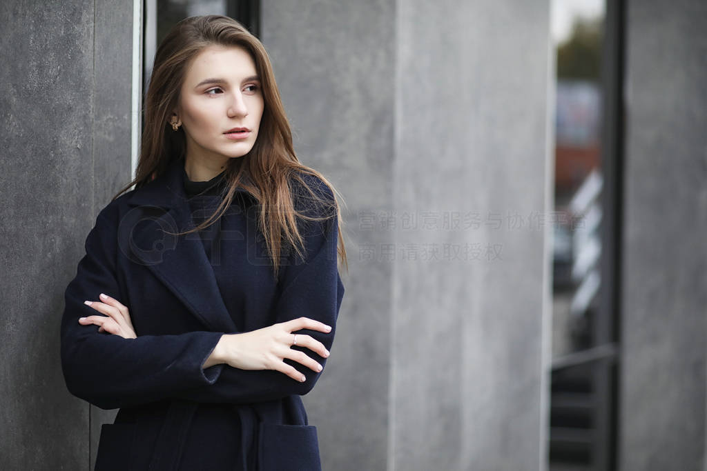 Beautiful girl in a coat in business downtown