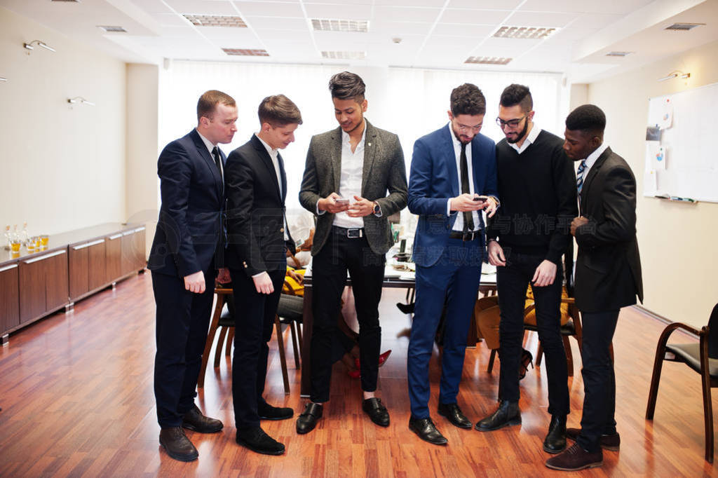 Six multiracial business mans standing at office and use mobile