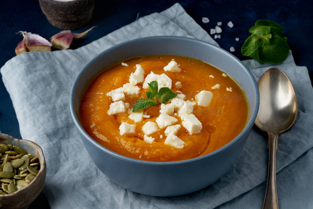 Pumpkin cream soup with feta cheese, autumn homemade food, dark