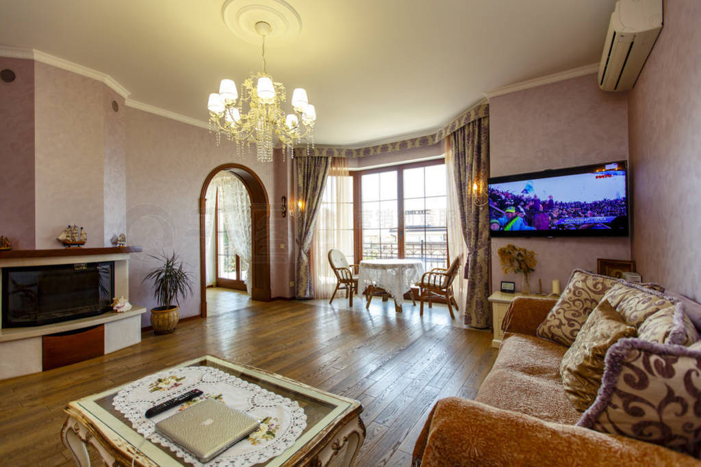 Hall in classic style with two sofas, coffee table, TV. A round