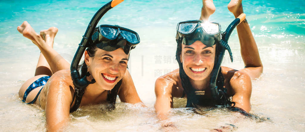Two happy girlfriends with snorkeling mask enjoying on tropical