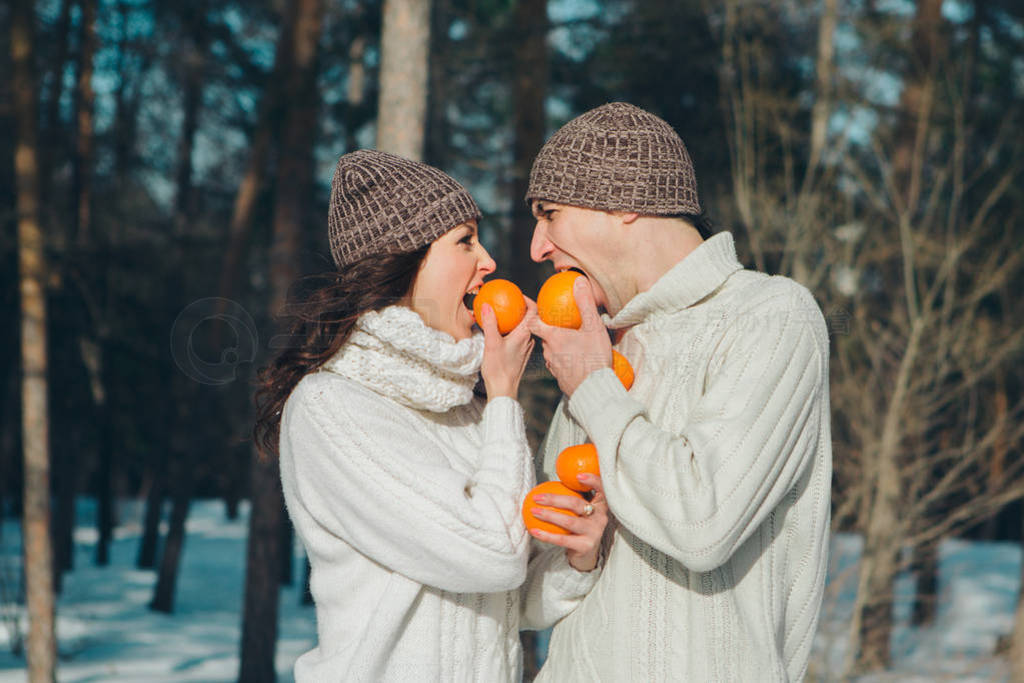 s day: couple in love with oranges on the background of winter l