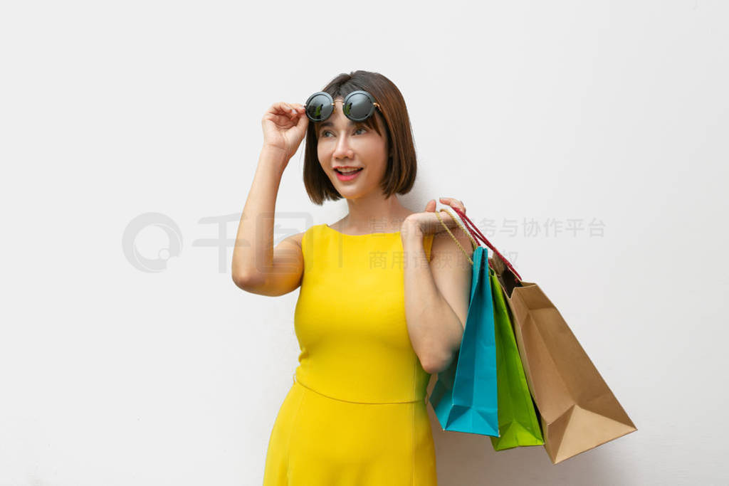 Portrait of beautiful girl wearing dress and sunglasses holding