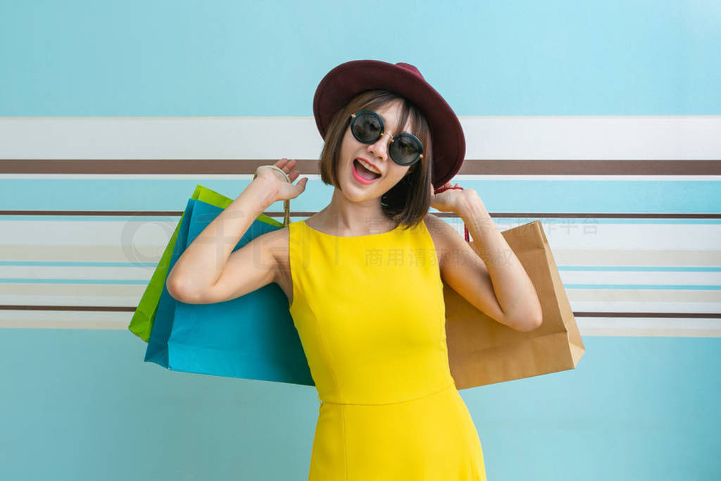 Portrait of beautiful girl wearing dress and sunglasses holding