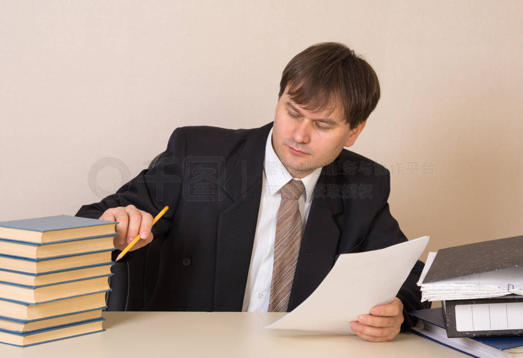 Employee counts books with documents at the table in the office