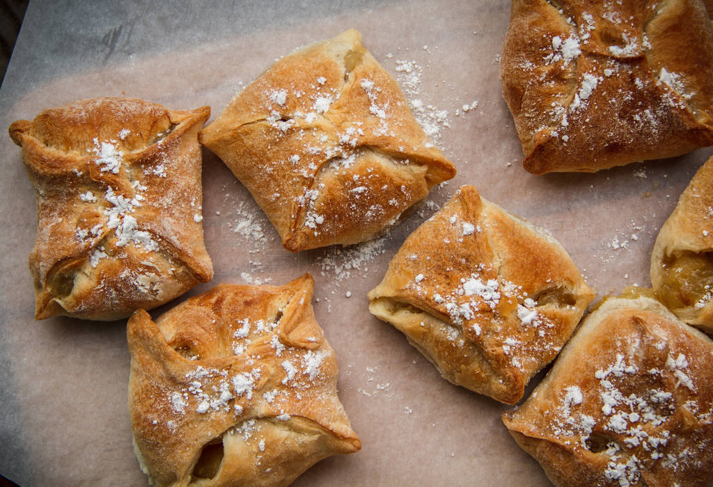 Apple buns. Fresh cakes. Fruit pies lie on a wooden table.