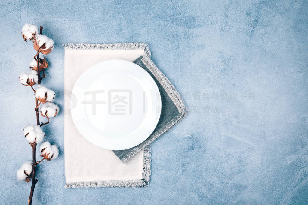 Empty circle plate on linen napkins decorated with cotton flower