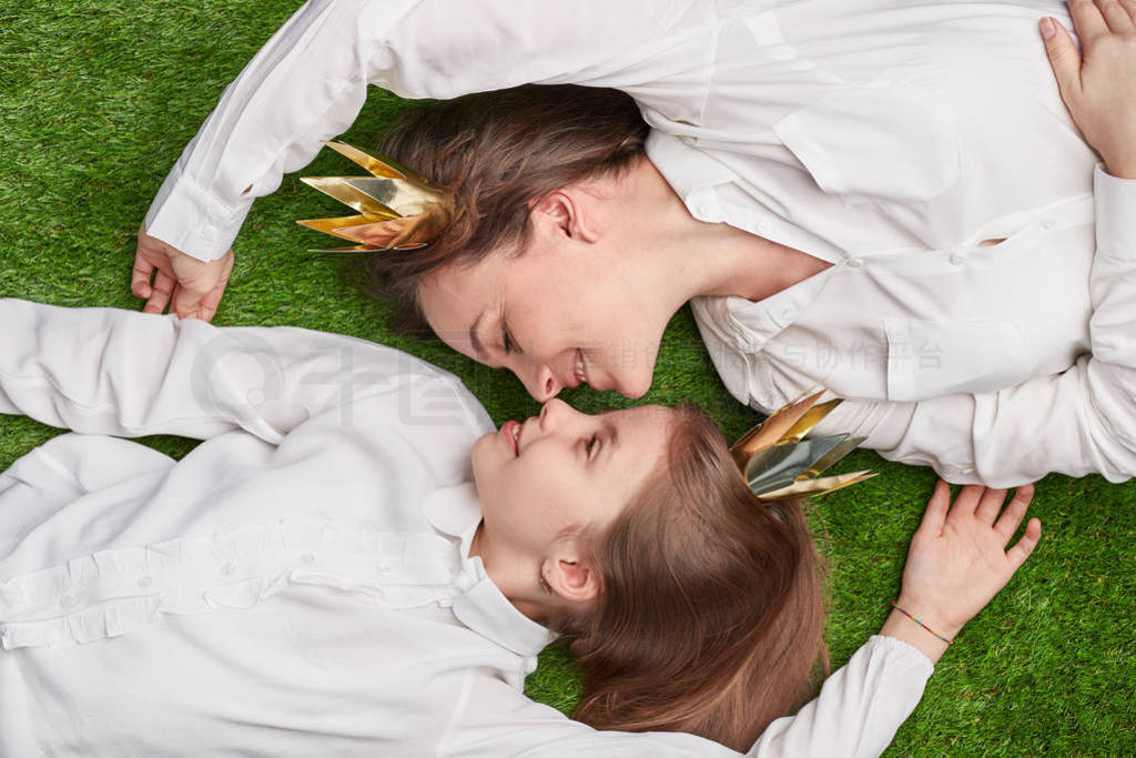 Loving mother and daughter lying on meadow