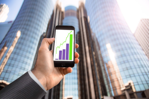 成功的商人，握着手机的手 app 技术图表气压计成功市市中心建筑摩天大楼