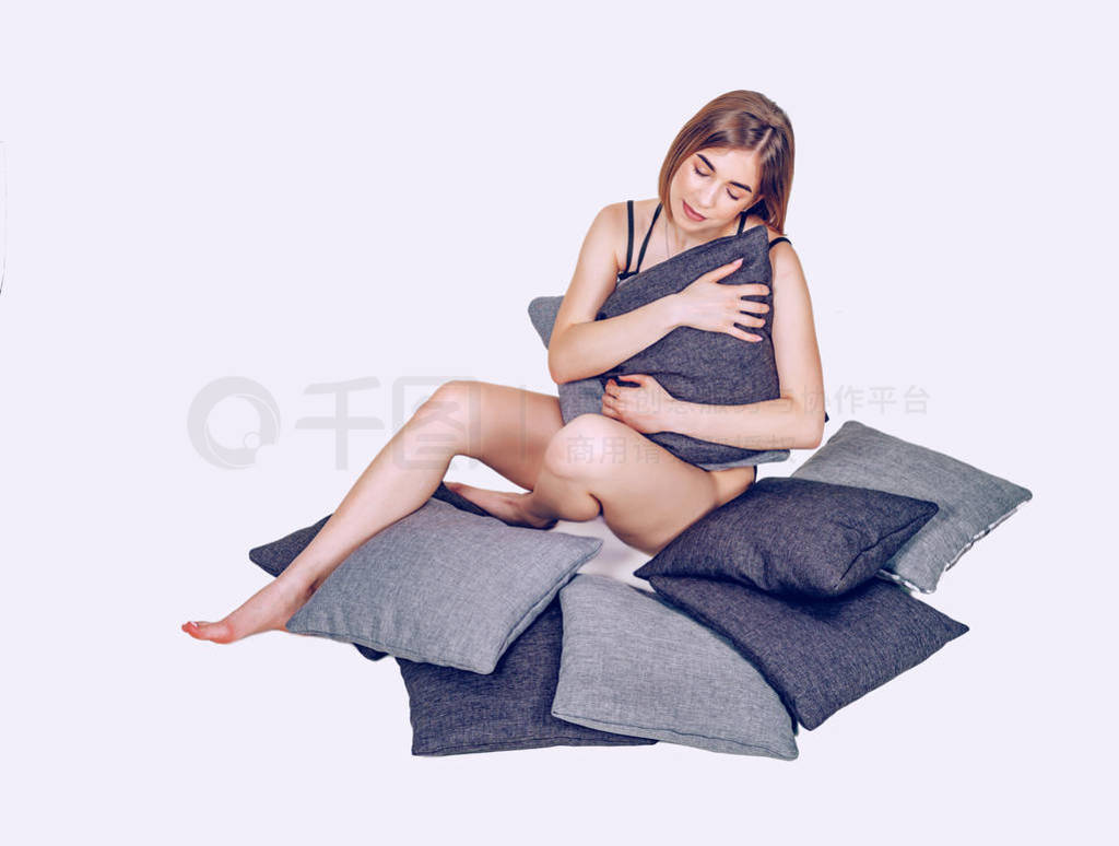 Relaxed girl hugging pillows while sitting on the floor. Sleep,
