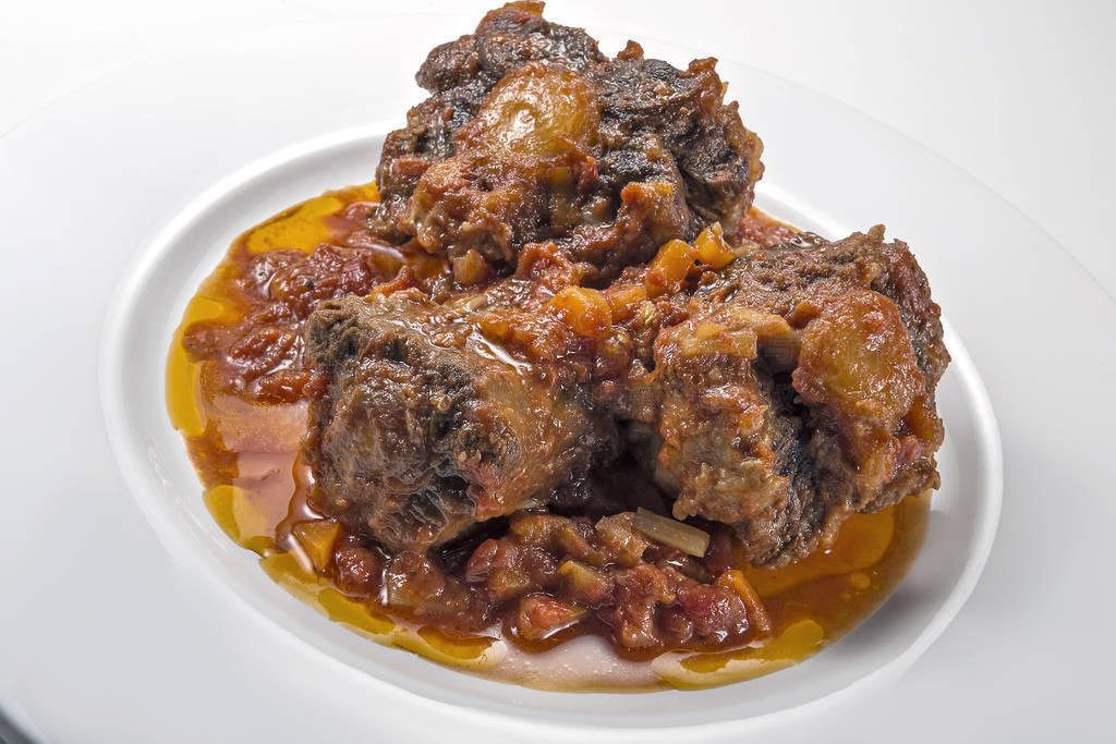 Isolated Dish with a portion of oxtail stewed vaccinara