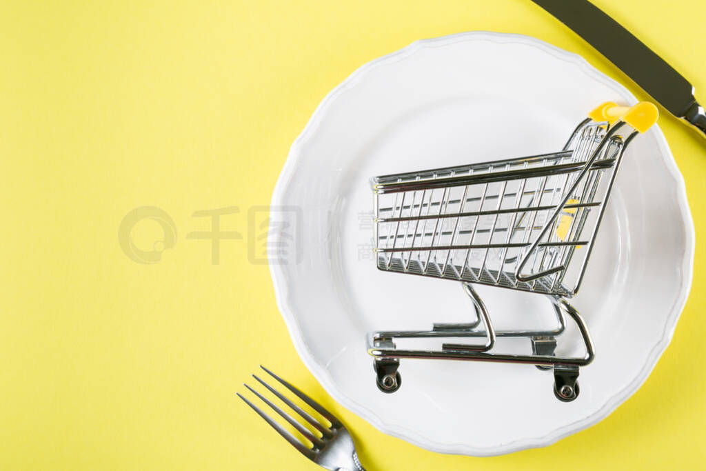 Empty food cart on white plate. Grocery shopping concept, weekly