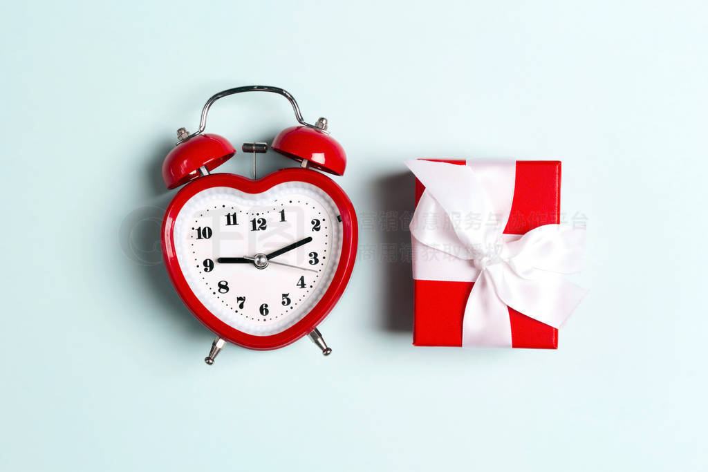 Alarm clock and gift box on a blue background.