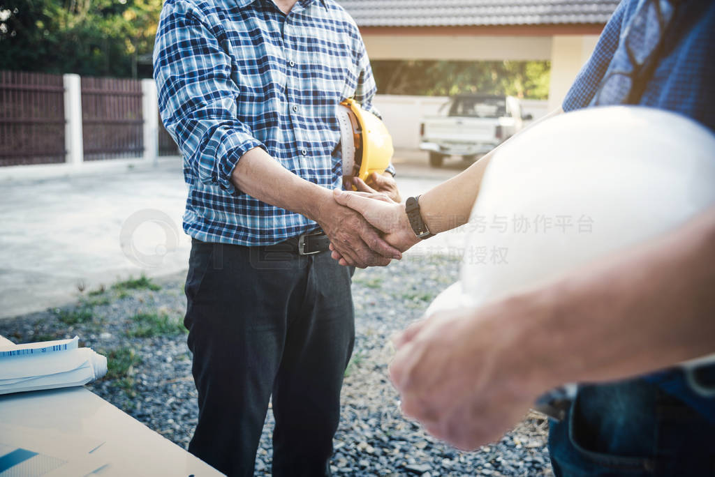 Engineers shaking hands at construction site house building for