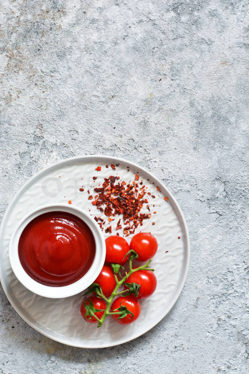 Classic tomato sauce with spices on a concrete background.