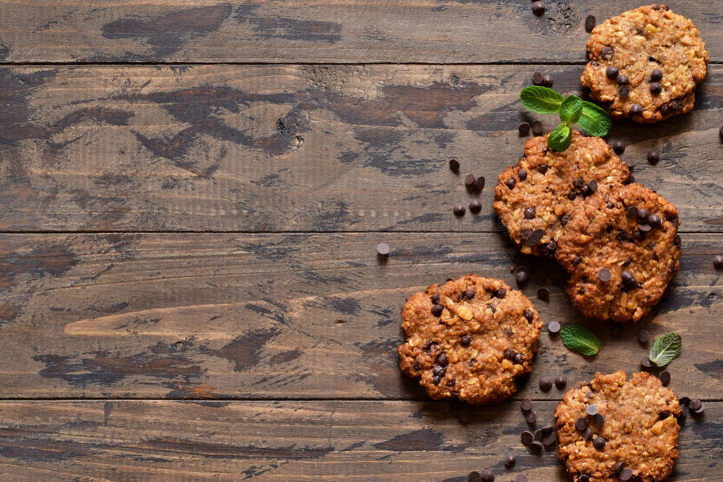 Oatmeal cookies with chocolate drops on a wooden background.