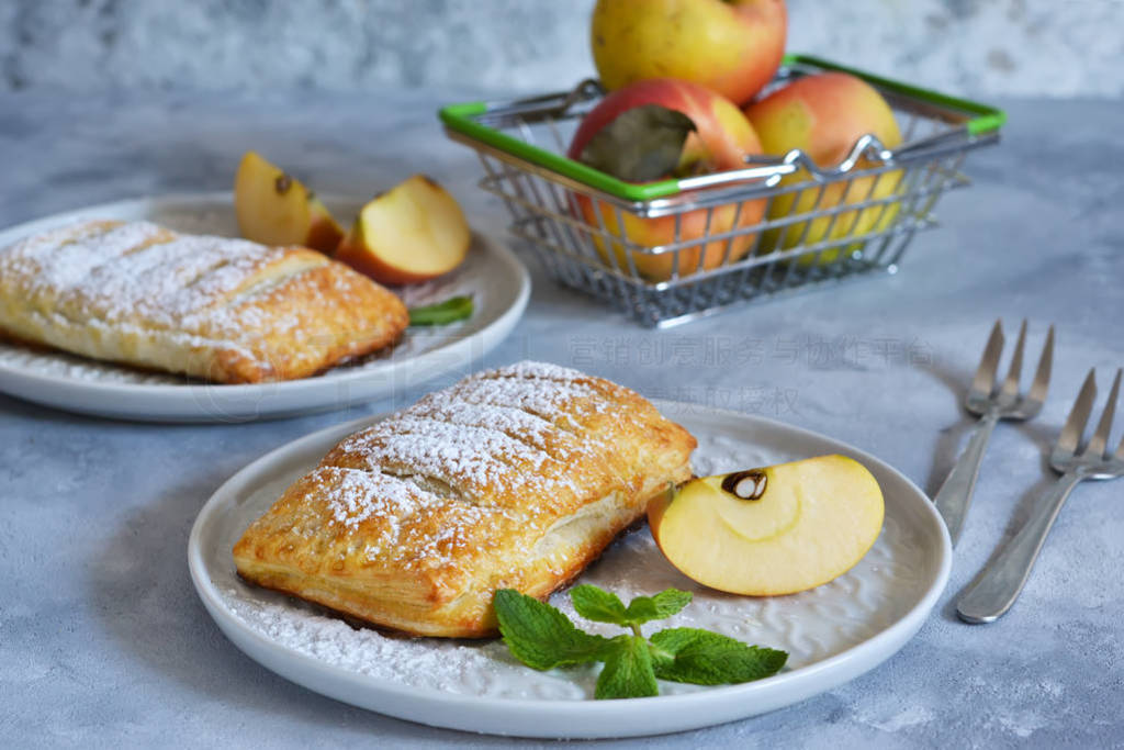 Puffs with apples and cinnamon in a plate on the kitchen table.