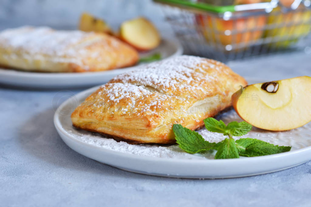 Puffs with apples and cinnamon in a plate on the kitchen table.