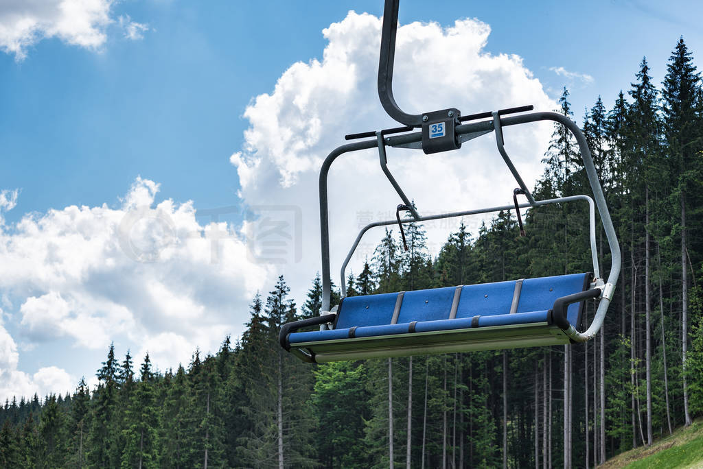 Empty ski lift on a background of forest and blue sky. Holidays