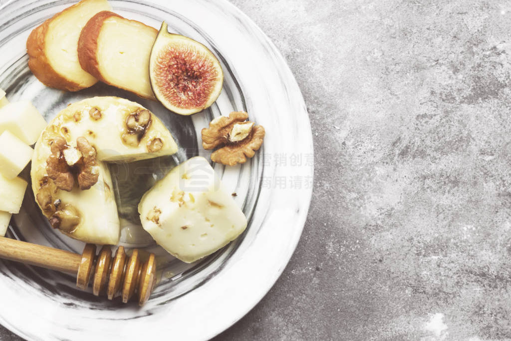 Snacks with wine - various types of cheeses, figs, nuts, honey,