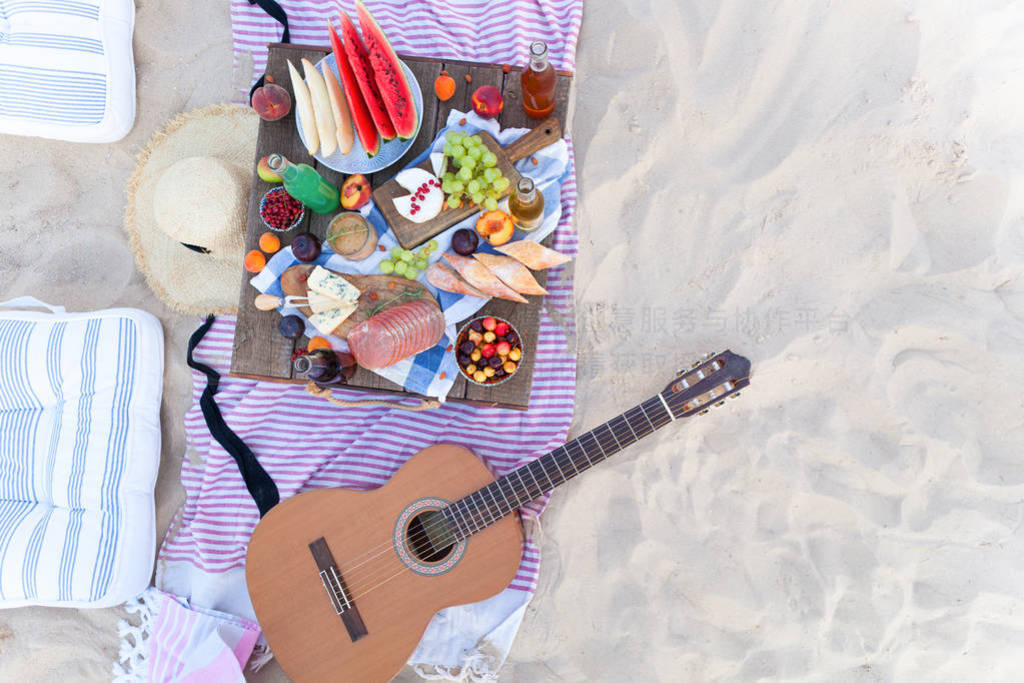 Picnic on the beach at sunset in the style boho, food and drink