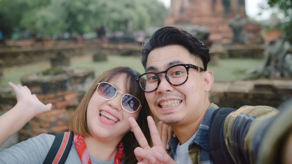 Traveler Asian couple using smartphone taking selfie while spend