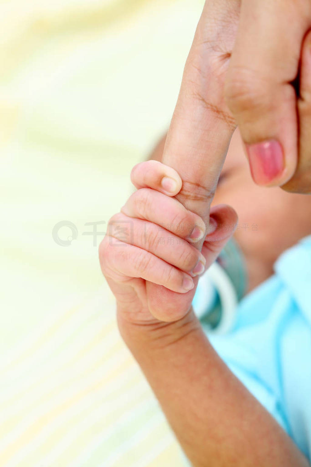 s hand grasping the finger of parent