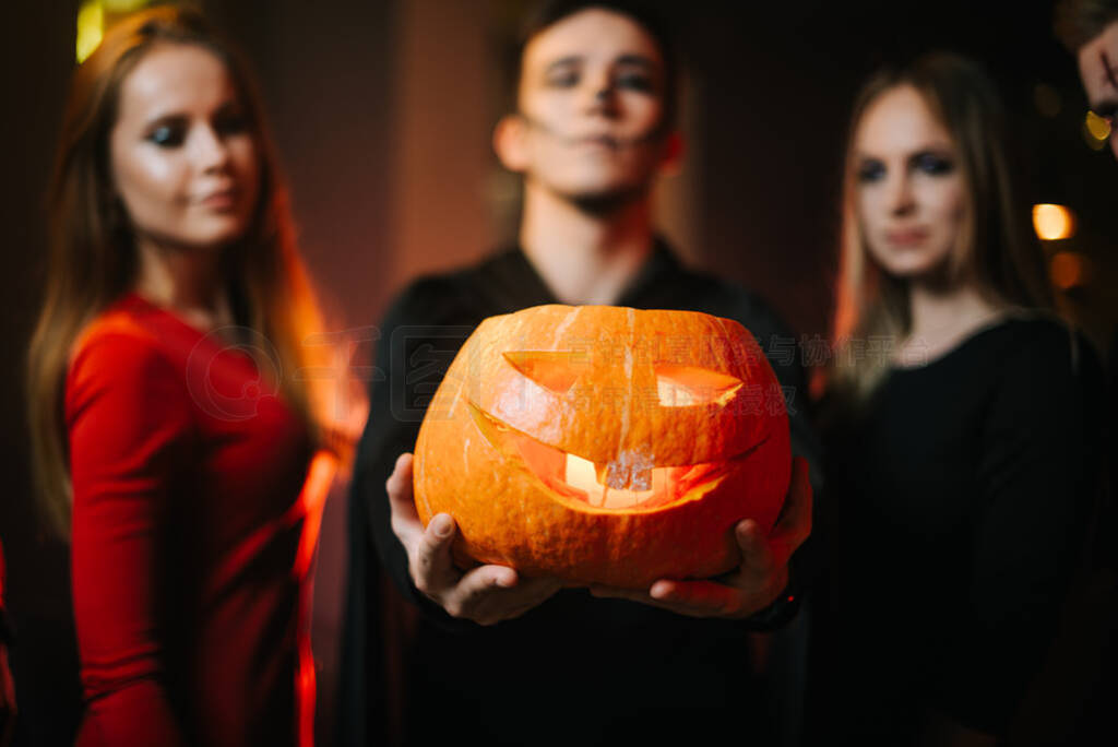 Group of friends celebrating Halloween. Young man wearing zombie