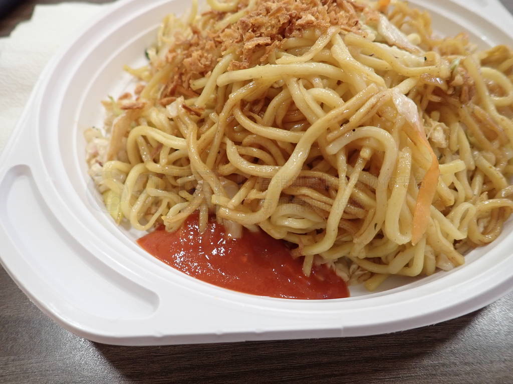 chinese noodles fire with vegetables on a plastic plate