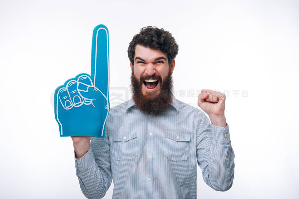 Portrait of a cheerful excited man with a foam finger shouting