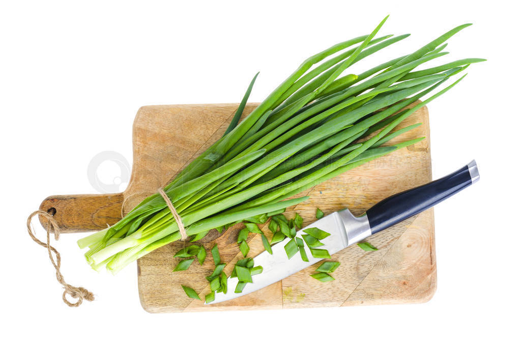 Use of fresh green onions in cooking, kitchen wooden board.