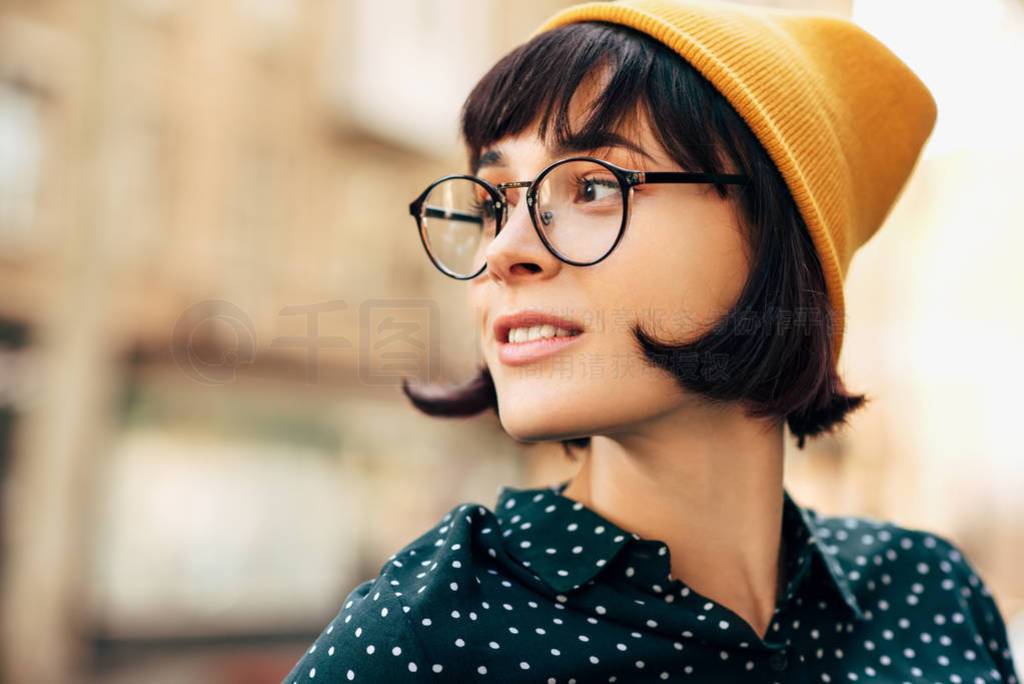 Close-up portrait of beautiful young woman wearing yellow hat an