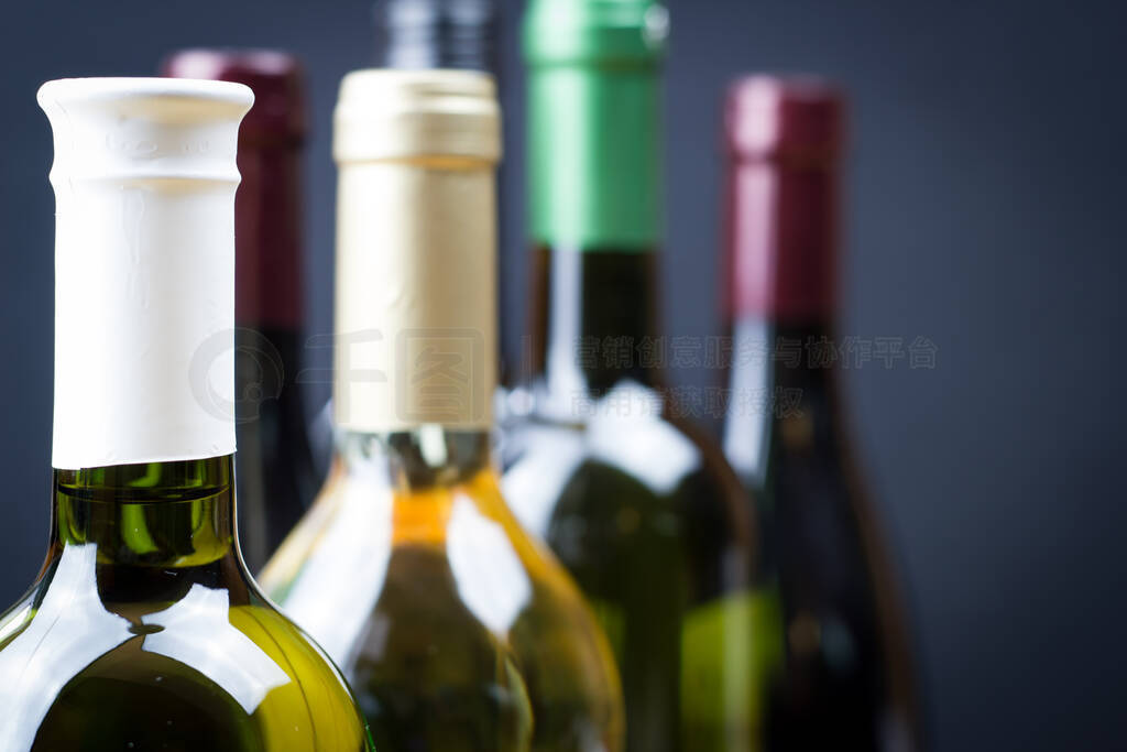 Close up of wine bottles in a row isolated on a gray background,