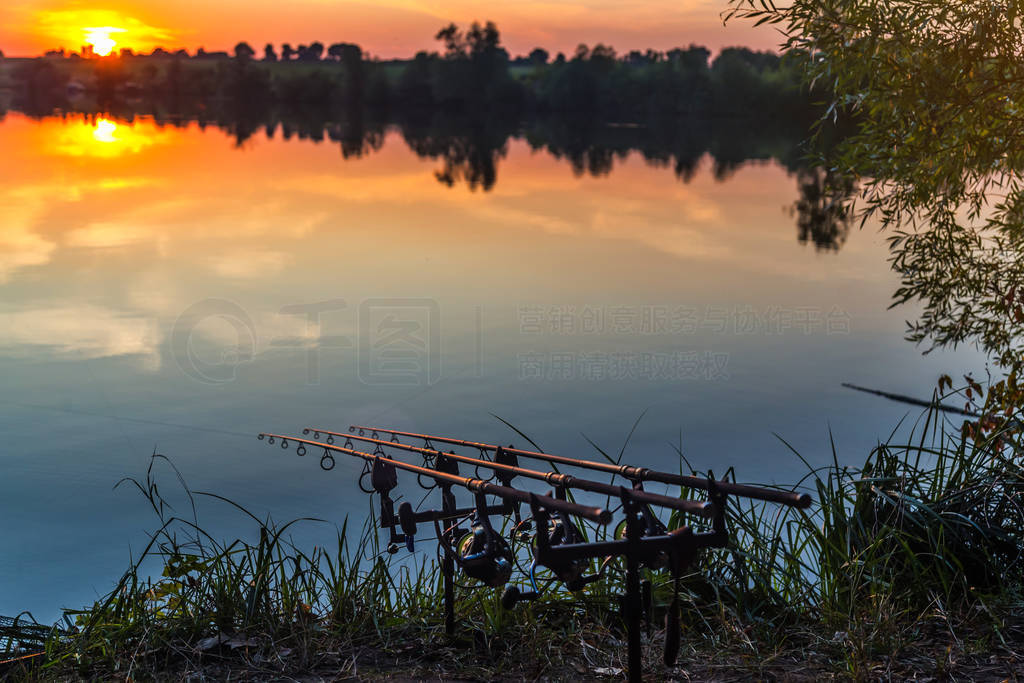 Fishing adventures, carp fishing. Angler, at sunset, is fishing