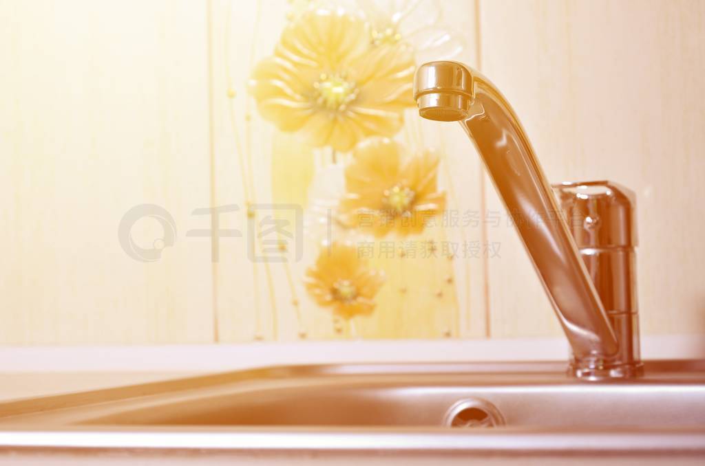 Empty clean silvery kitchen sink and water faucet close up