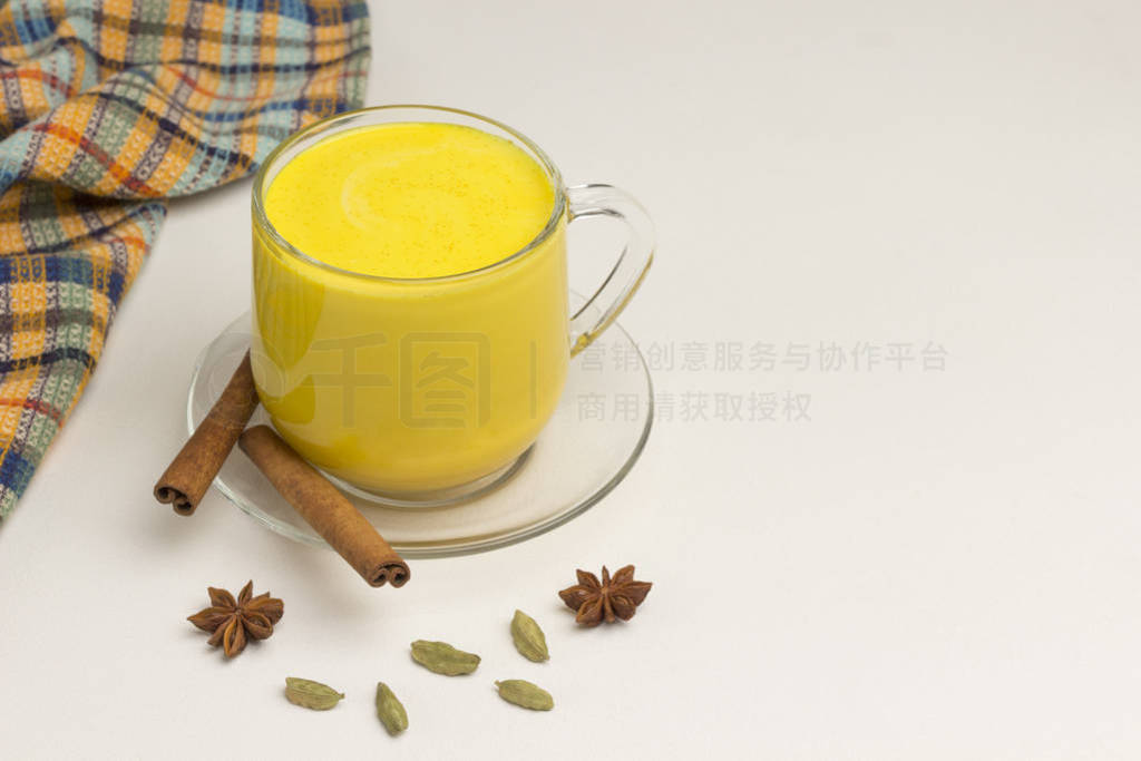 Golden latte on white background with ingredients for cooking.