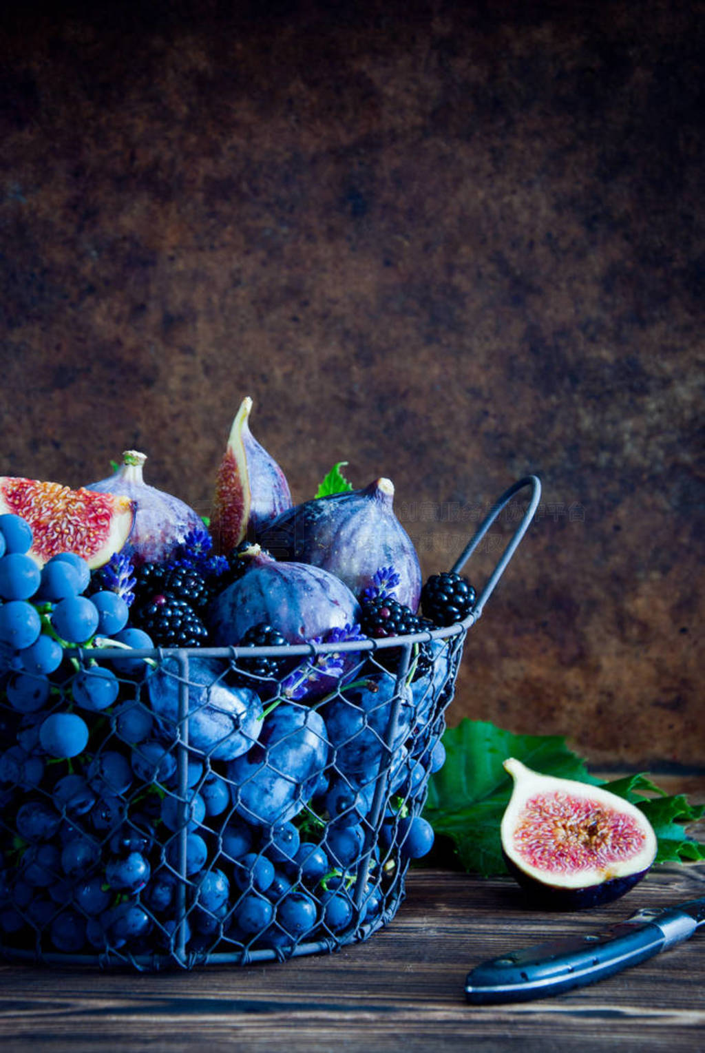 Fresh figs, grapes, prunes and dewberry in a metal basket